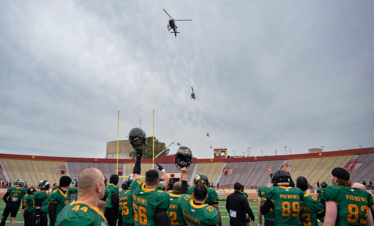 Law Hogs team members cheer as a formation of emergency services helicopters flies over Hughes Stadium before the 50th Pig Bowl on Saturday, Jan. 27, 2024. The 51st Pig Bowl this Saturday will benefit 40 Southern California first responders who’ve lost their homes in Los Angeles County wildfires.