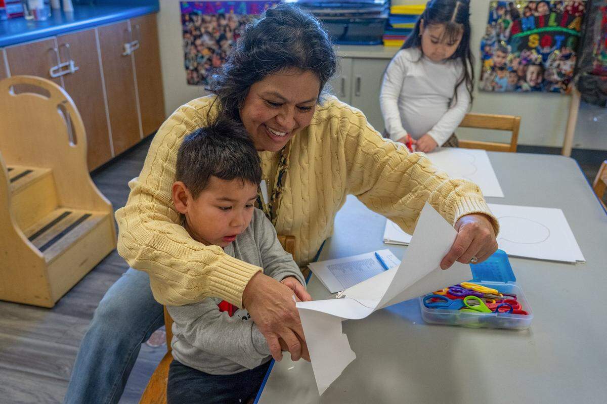 Teacher Dometila Casillas helps Shann Gomez Molina, 4, cut a shape out of paper as Maria Sandoval, 4, participates in the background during a Head Start preschool program in Sacramento on Wednesday. “I like this age because you’re so able to build their character, and the skills they learn at this age are going to help them when they get to kindergarten,” Casillas said.