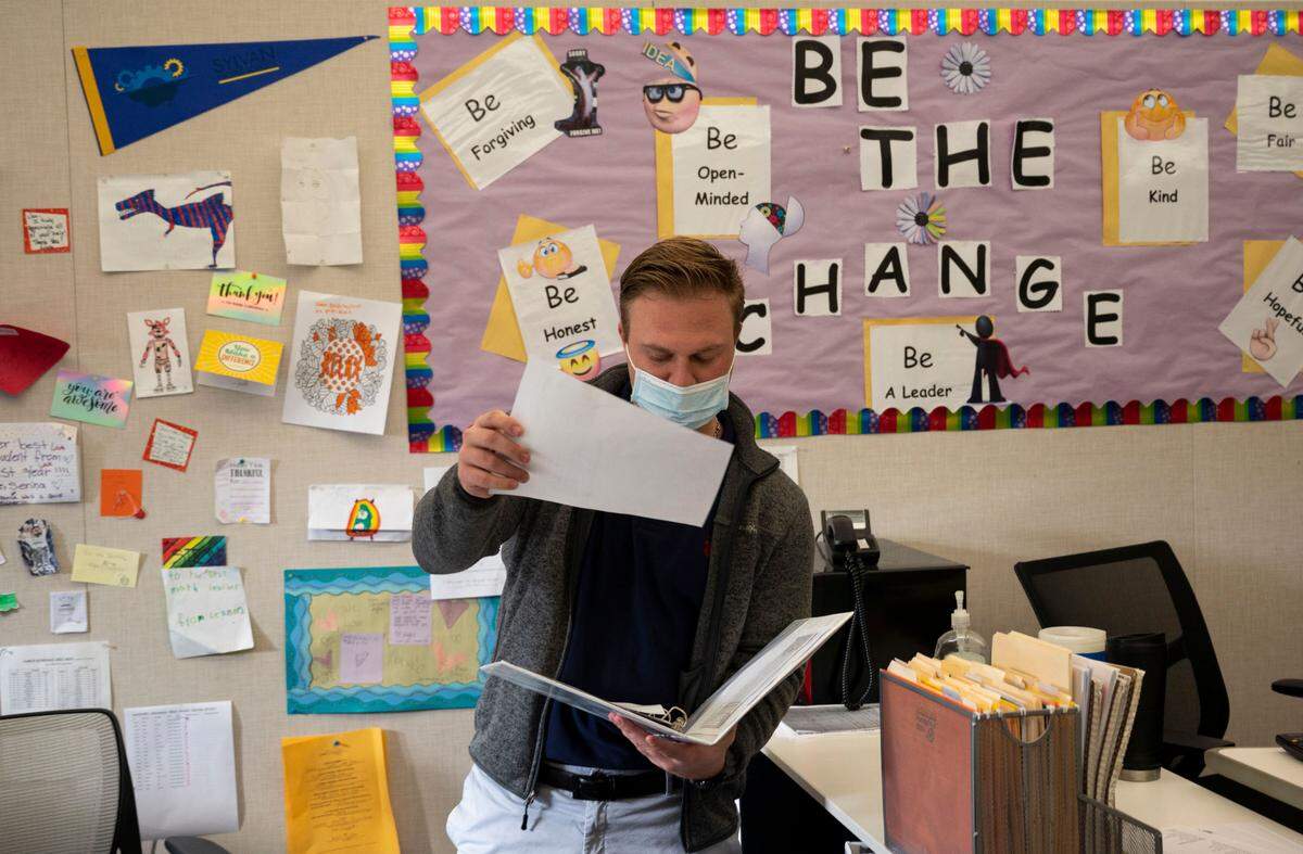 Substitute teacher Hank Pankratz gets out a lesson plan while starting class at Sylvan Middle School in Citrus Heights on Thursday, Dec. 9, 2021. His grandfather taught at the school for 35 years, and he said he’s following in his footsteps.