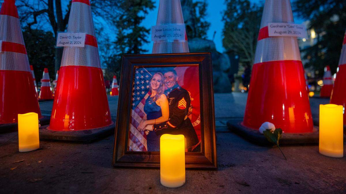 A framed photograph of Michelle Silva and her husband José Luis Silva stands next to the cone bearing his name during a vigil hosted by Slow Down Sacramento on Thursday at Fremont Park. José Luis was killed while riding motorcycle in midtown in August. He was 55. Michelle spoke at the vigil, calling for the city to take more action on improving infrastructure. “These tragedies are not inevitable – they are preventable,” she said.