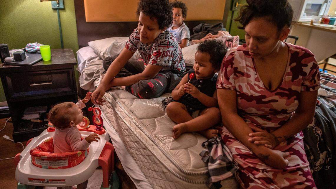 Ashley Patterson, 30, who has been staying at the Extended Stay America motel with children Jason Brooks, Jr., 11, giving Angel McDew, 9-months, a taste of his lollipop, Ashton McDew, 5, back center, and Allayah Walker, 2, right, says it’s frustrating for the family of five to live in a cramped room on Thursday May 20, 2021 in Sacramento. She said every where she calls there is no housing.