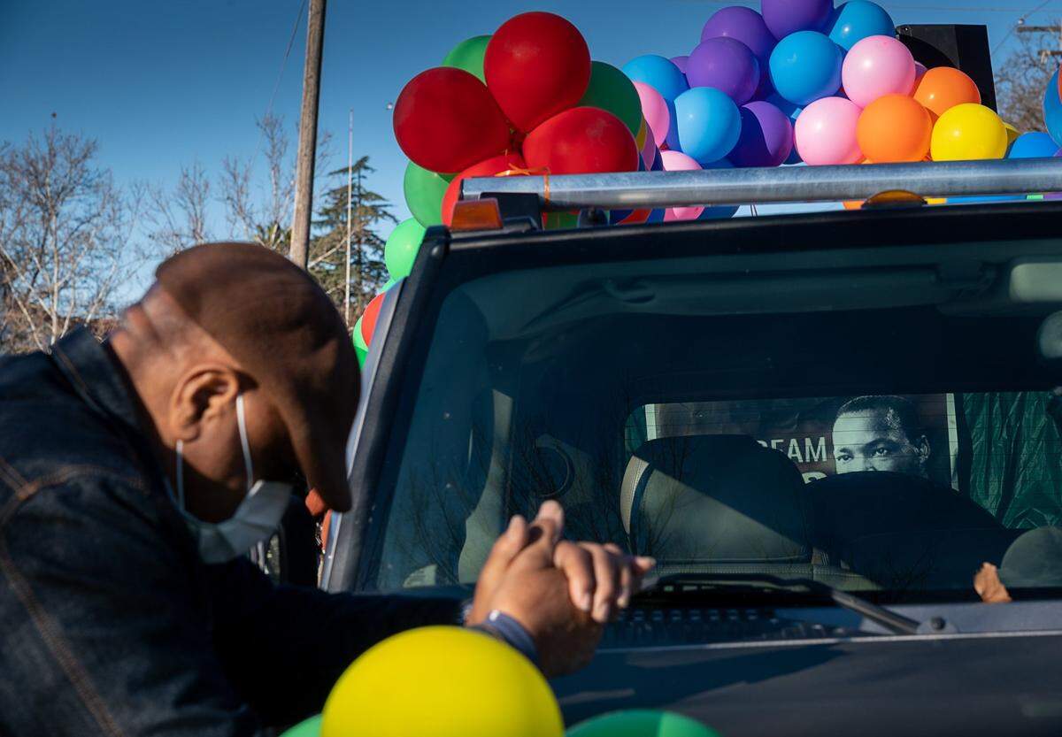 Lee Suggs prays before the start of the #ReclaimMLK Day car caravan in celebration of Martin Luther King Jr. Day at Grant High School in Sacramento on Monday.
