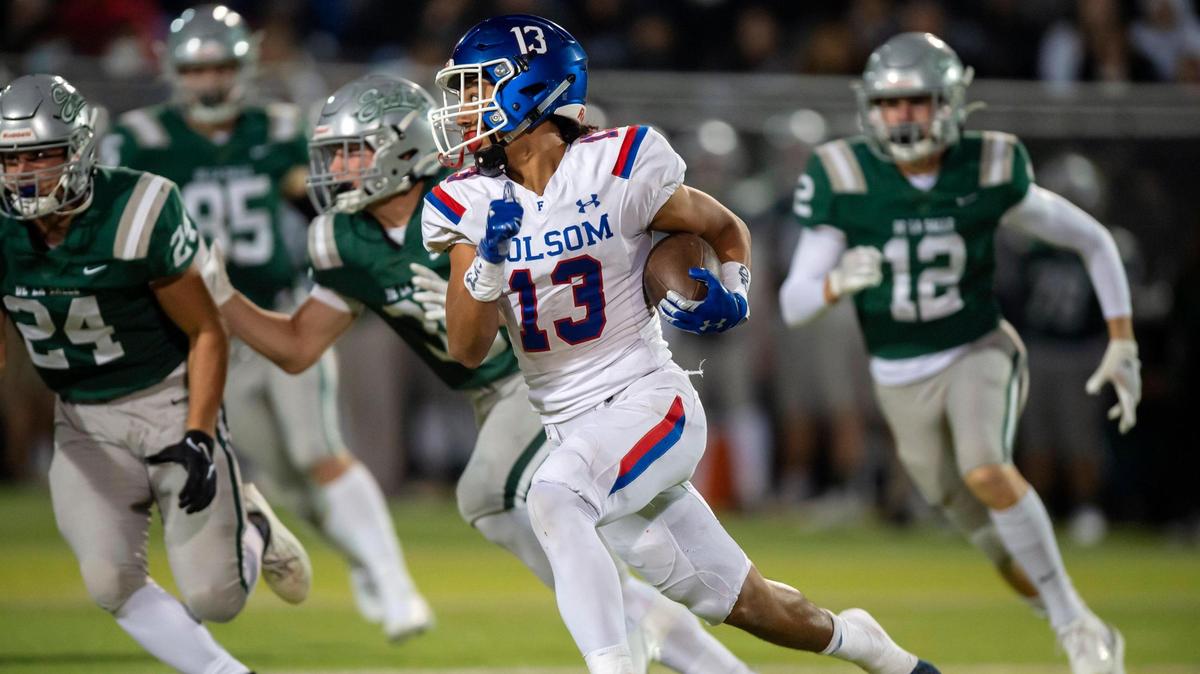 Folsom’s Rico Flores Jr. (13) runs the ball for a first down during the third quarter of the CIF Division I regional finals game at St. John Baptist de la Salle Stadium in Concord on Friday, Dec. 3, 2021. The Bulldogs won 28-27.
