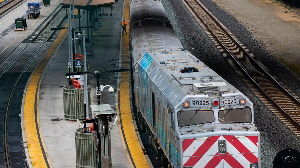 A lone worker cleans near an Amtrak train at the Sacramento Valley Station in March 2020. Amtrak is offering discounted fares for friends of full-price ticket purchasers taking weekend trips along the Capitol Corridor.