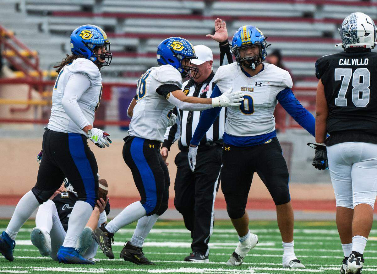 Sutter Huskies defensive end Troy Bowens (0) is congratulated by defensive end Richard Creer (28) after he sacked Casa Roble Rams quarterback Aidan Lopez in the CIF Sac-Joaquin Section Division V championship at Hughes Stadium in Sacramento on Friday.
