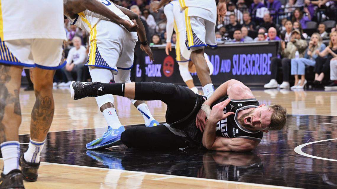 Sacramento Kings center Domantas Sabonis writhes in pain after being stomped on by the Golden State Warriors’ Draymond Green in the fourth quarter of Game 2 of the first-round NBA playoff series at Golden 1 Center on Monday, April 17, 2023. Green was ejected from the game.