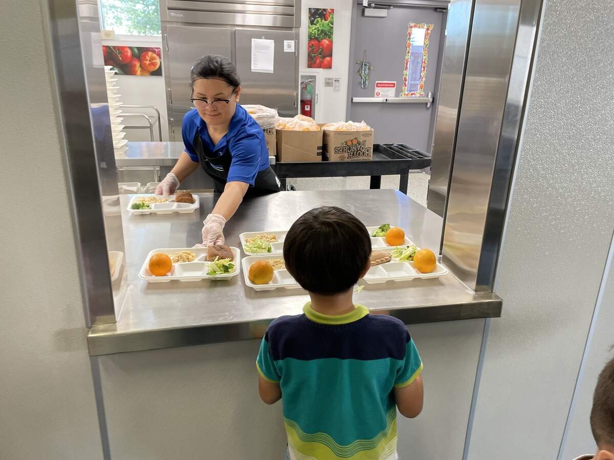 A kitchen staff member at Ridgepoint Elementary School in Foothill Farms serves a meal to a young student in September 2025. According to Twin Rivers Unified School District Nutrition Services’ Facebook, the school revamped its kitchen leading up to the 2025-2026 school year with updated appliances to prepare breakfast, lunch and supper meals for hundreds of students.
