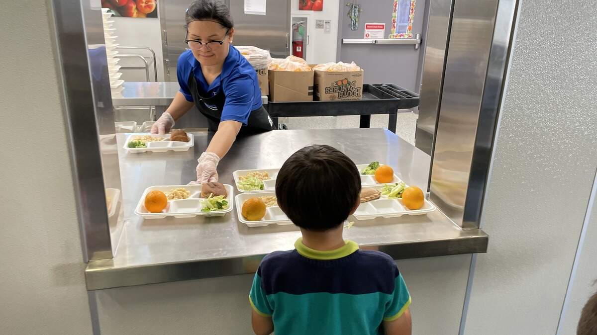 A kitchen staff member at Ridgepoint Elementary School in Foothill Farms serves a meal to a young student in September 2025. According to Twin Rivers Unified School District Nutrition Services’ Facebook, the school revamped its kitchen leading up to the 2025-2026 school year with updated appliances to prepare breakfast, lunch and supper meals for hundreds of students.