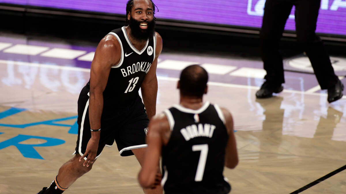 Brooklyn Nets guard James Harden (13) reacts towards forward Kevin Durant (7) during an NBA basketball game against the Milwaukee Bucks, Monday, Jan. 18, 2021, in New York. The Nets won 123-125. (AP Photo/Adam Hunger)