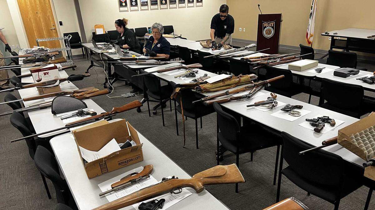Police officials process guns turned in during a May 21, 2022, gun buyback in which residents were given $50 gas gifts cards in exchange for their firearms in Sacramento, California.