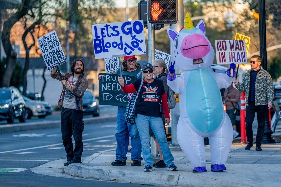 Daniel Amaro, left, protests at the corner of 16th and Broadway in Sacramento on Monday. Amaro said he saw an Instagram post about the “No War in Iran” demonstration and had to join it. “This is a nuclear provocation. I had to show up,” Amaro said.