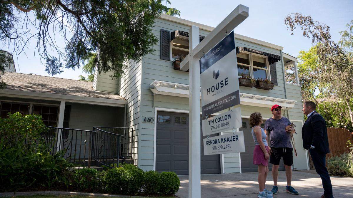 Sacramento real estate agent Tim Collom, right, talks with Dale and Debbie Snapp outside an open house Saturday, May 7, 2022, in East Sacramento. Collom said the spring housing market is still strong but has slowed from two months ago. Homes that were getting five to 10 offers earlier this year are now attracting one or two.