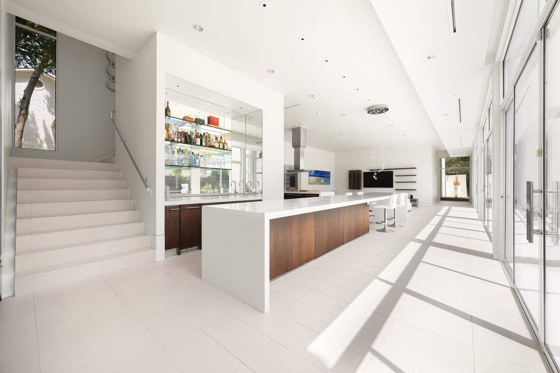 A stunning open-concept kitchen anchors the heart of the home, featuring a 22-foot island, top-tier Miele and Sub-Zero appliances, wine fridges, and direct flow into the family room—ideal for both entertaining and everyday living.