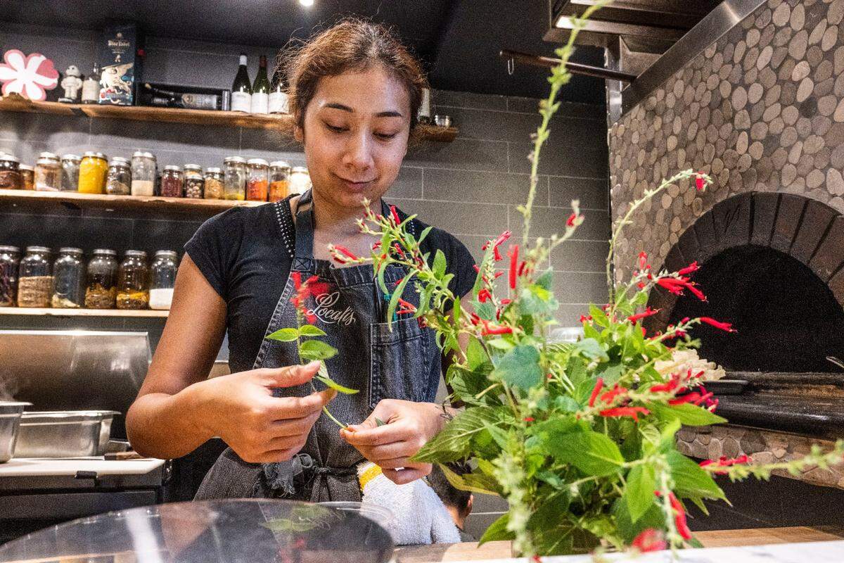 Amanda Smith, executive sous chef at Localis, cuts pineapple sage leaves and flowers on Dec. 9. All Localis employees make at least $55,000 per year plus health insurance and a month of PTO, rare benefits in the restaurant industry.