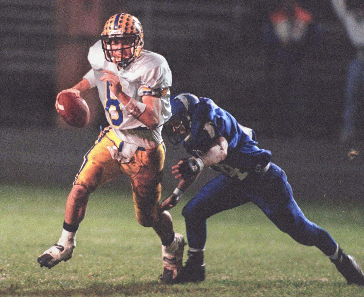 Grant High School quarterback Chad Elliott darts out of the pocket as he tries to elude an Atwater defender during a section championship game in Stockton in 1996. Elliott also quarterbacked Nevada Union to a section title.