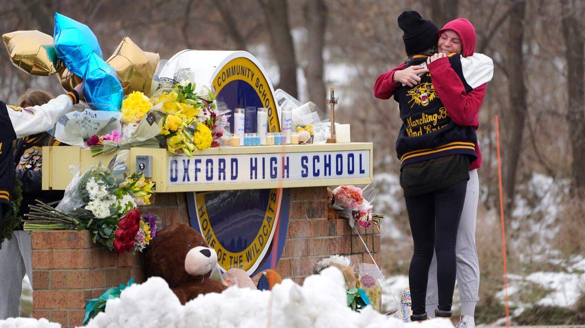 Students hug at a memorial at Oxford High School in Oxford, Mich., Wednesday, Dec. 1, 2021. Authorities say a 15-year-old sophomore opened fire at Oxford High School, killing four students and wounding seven other people on Tuesday. (AP Photo/Paul Sancya)
