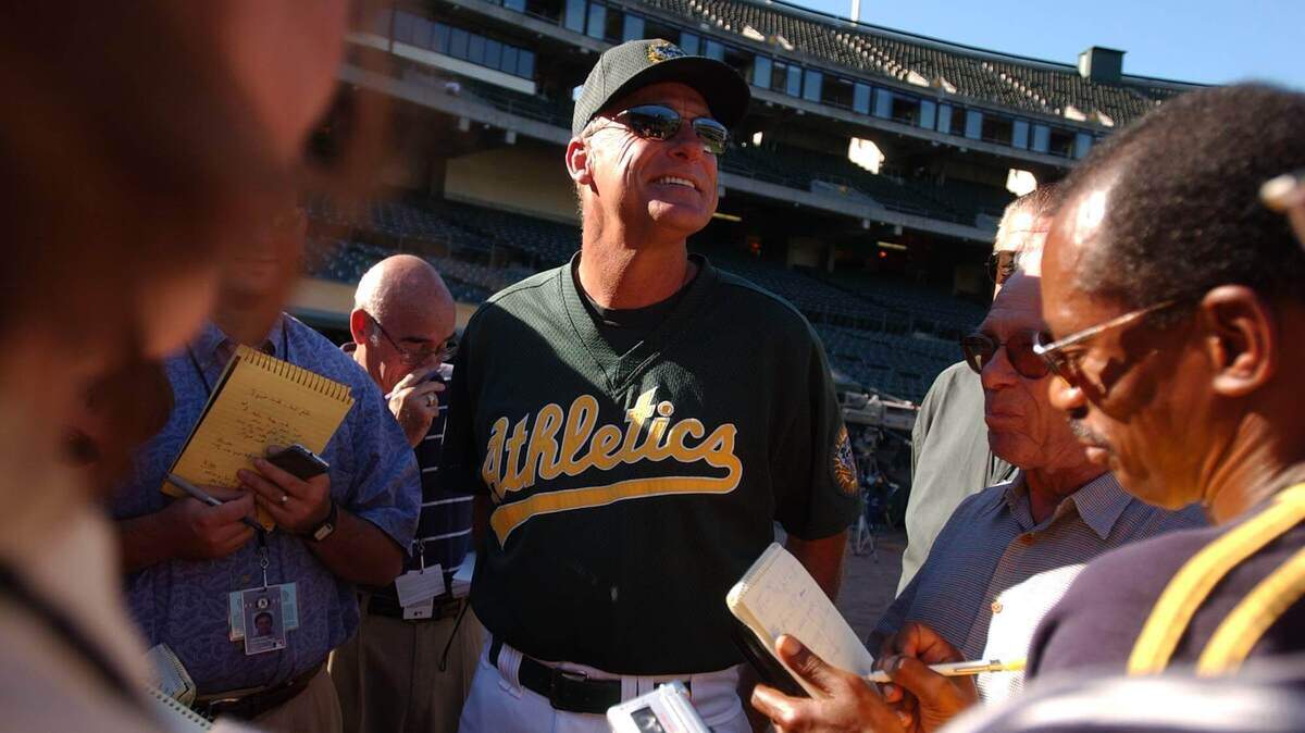 A’s manager Art Howe, center, addresses the media before a home game against the Kansas City Royals in September 2002. Howe is in a Houston hospital battling the coronavirus.