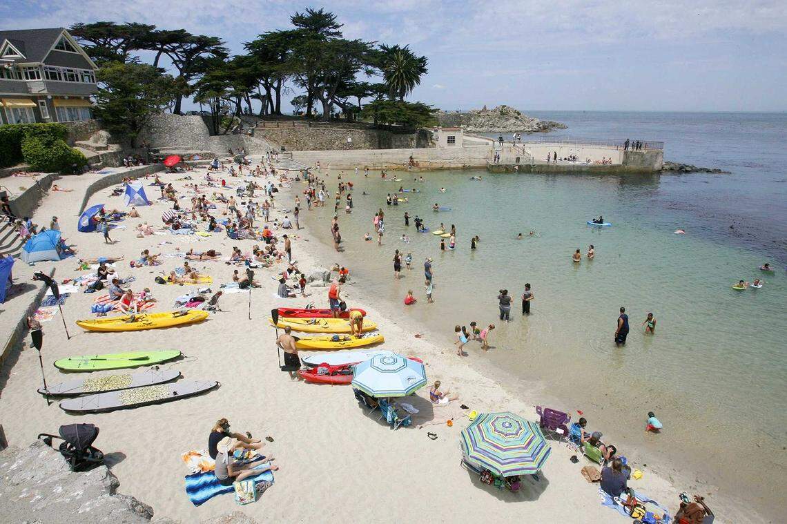 People crowd the beach at Lovers Point Park in Pacific Grove in 2015. A swimmer was seriously injured in a shark attack near the beach Wednesday. A Folsom couple were among the bystanders who rushed in to help.