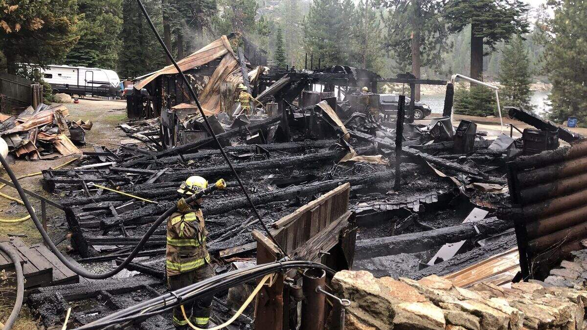 Firefighters sift through the wreckage of the Bear River Lake Resort’s main lodge after it burned down in a fire in the early morning of Sunday, Sept. 3, 2023. The lodge was a total loss, according to the Amador Fire Protection District. County officials said surrounding buildings, facilities and campgrounds remained intact.