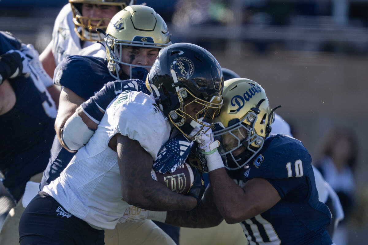 UC Davis Aggies defensive back Jayden Stanley (10) tackles Sacramento State Hornets running back Rodney Hammond Jr. (2) in the first half in the Causeway Classic on Saturday in Davis.