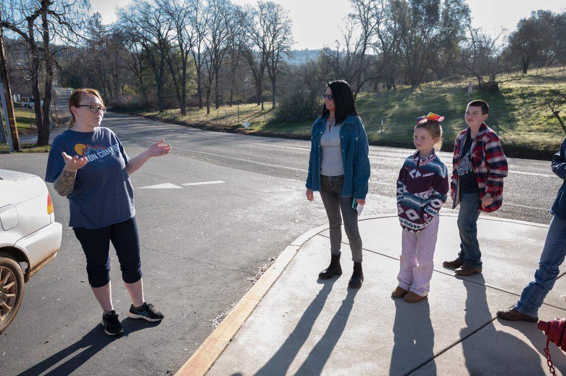 Joellene Vakulich, left, of Shingle Springs talks to Jill Boswell on Monday, Jan. 24, 2022, after she pulled her son from Buckeye Elementary School when she found out he would be tested for COVID-19 without her knowledge. Boswell’s children Leo, 10, and Kassidy, 7, wait for their mother after they were sent home for violating the state mask mandate.