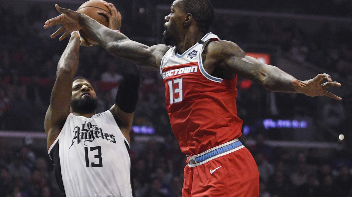 Los Angeles Clippers guard Paul George, left, shoots while Sacramento Kings center Dewayne Dedmon defends during the first half of an NBA basketball game in Los Angeles, Thursday, Jan. 30, 2020. (AP Photo/Kelvin Kuo)