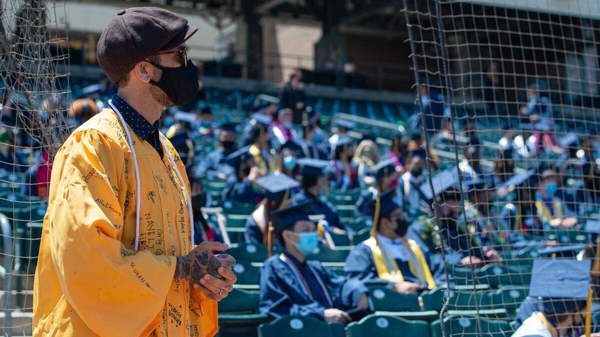 Inderkum government teacher Gabriel Gipe, who was selected by students as a speaker, wears a robe signed by the senior class at the school’s graduation ceremony at Sutter Health Park in West Sacramento in June 2021. Gipe left the school about six months later after he was secretly recorded by conservative activist group Project Veritas.
