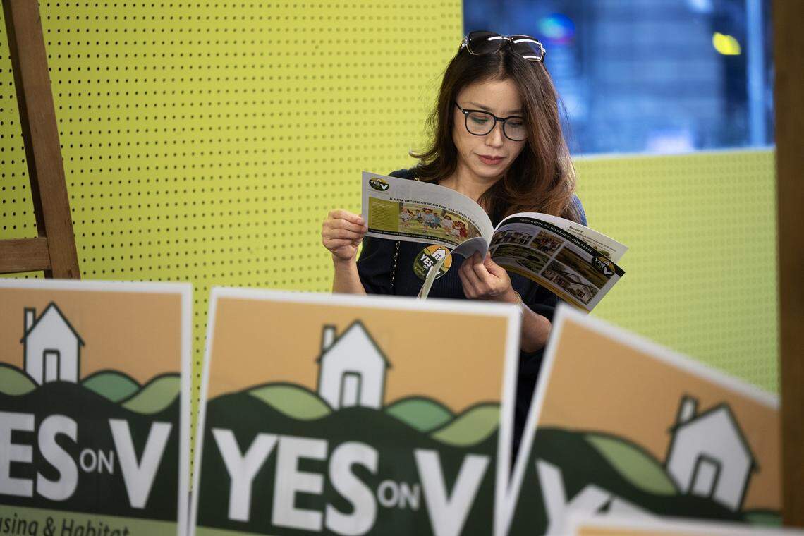Ping Zimmerman looks through some literature at the Yes on Measure V kick-off rally in Davis on Wednesday. The measure would allow a 498-acre development with 1,800 homes on the city's northern boundary to move forward.