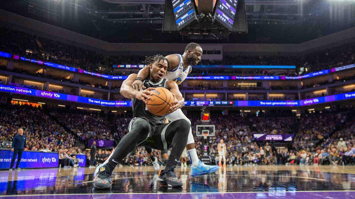 Sacramento Kings guard Davion Mitchell (15) is guarded under the basket by Golden State Warriors forward Draymond Green (23during an NBA game between the Sacramento Kings and the Golden State Warriors on Friday, April, 7, 2023 at Golden 1 Center.