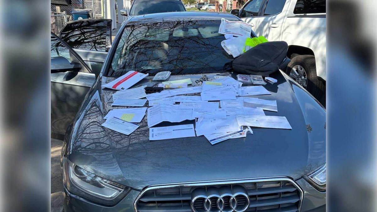 Stolen mail is seen on top of a gray Audi sedan in Folsom following the arrest of a second suspect in connection with a Feb. 6 break-in at a community cluster mailbox.