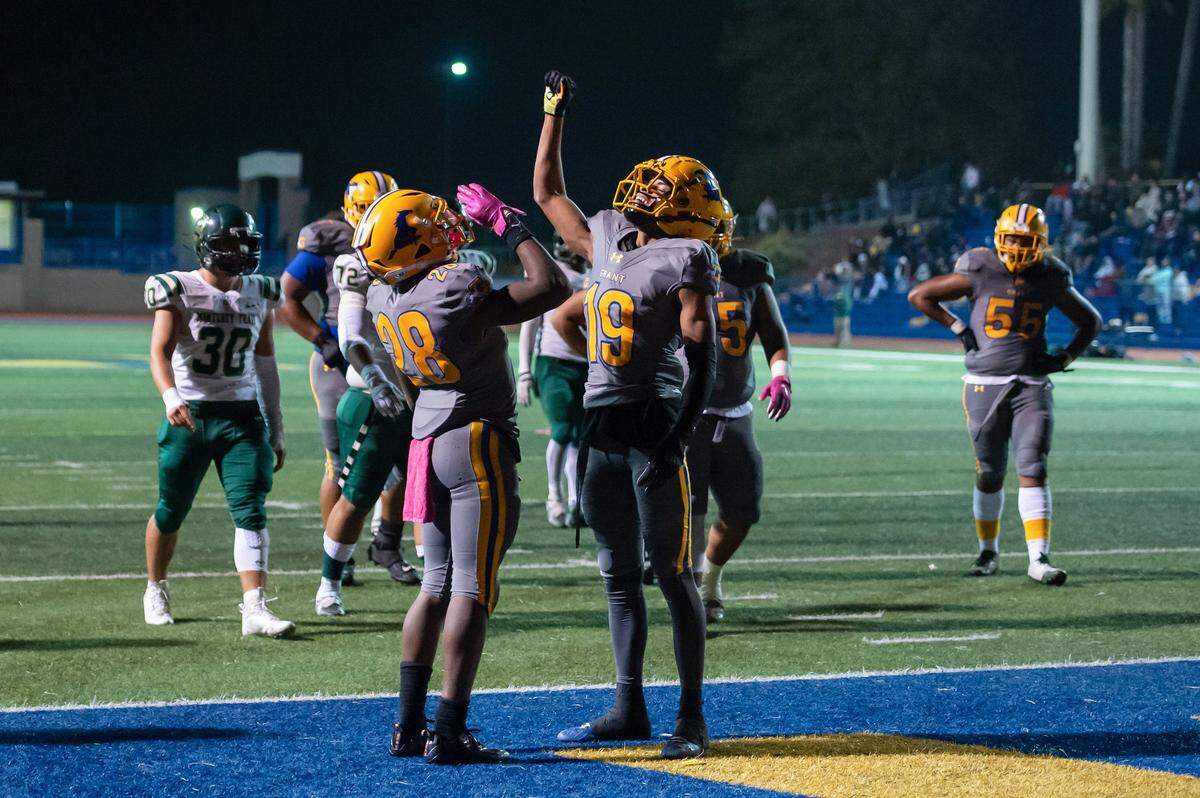 Grant’s Joshua Hamilton (28) celebrates with teammate Kyle Ryan (19) in the end zone after scoring a touchdown during the game Friday at Grant High School in Sacramento. A fatal shooting occurred in the parking lot near the end of the game.