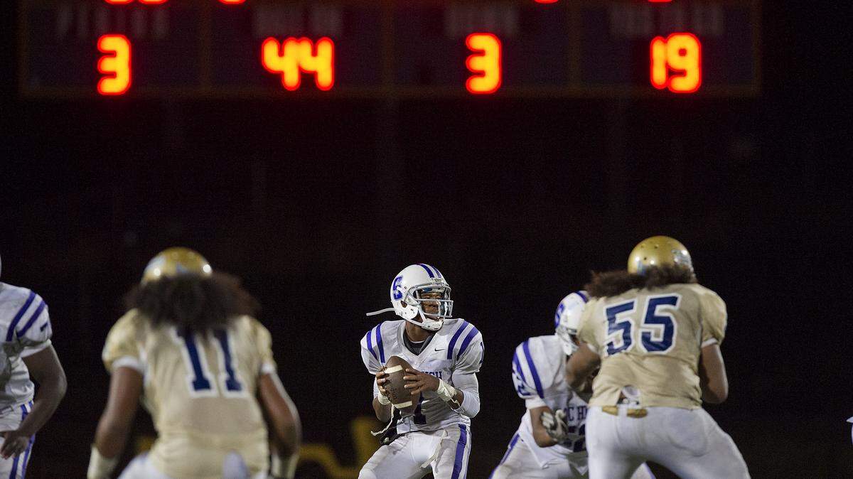The Dragons' Josiah Johnson drops back to pass during a game between the Sacramento High School Dragons and the Burbank High School Titans at Burbank High School in Sacramento on Friday, Sept. 28, 2012.