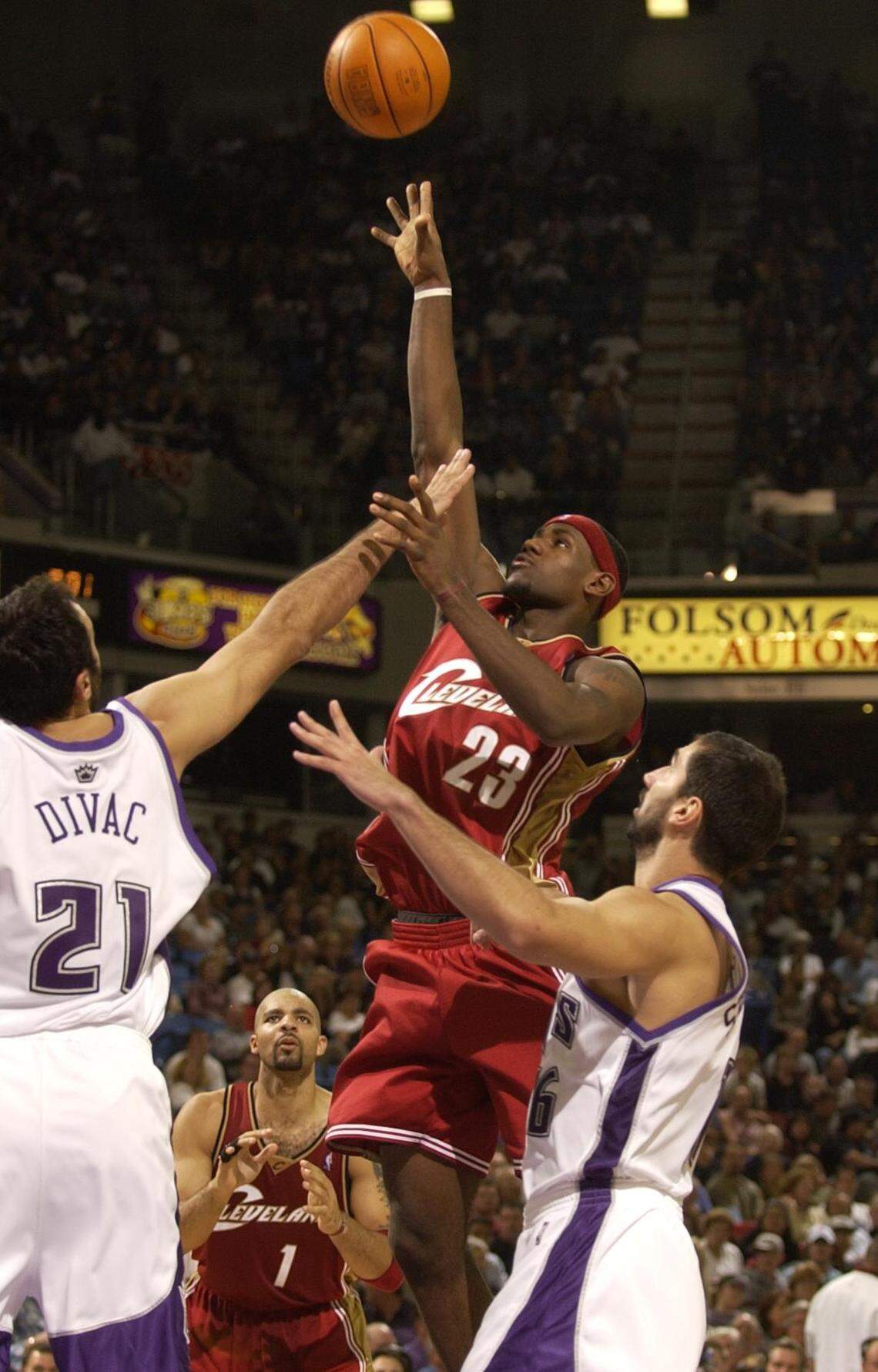 Cleveland Cavaliers forward LeBron James goes high for a shot over Kings center Vlade Divac in James’ NBA debut on Oct. 29, 2003, at Arco Arena in Sacramento.
