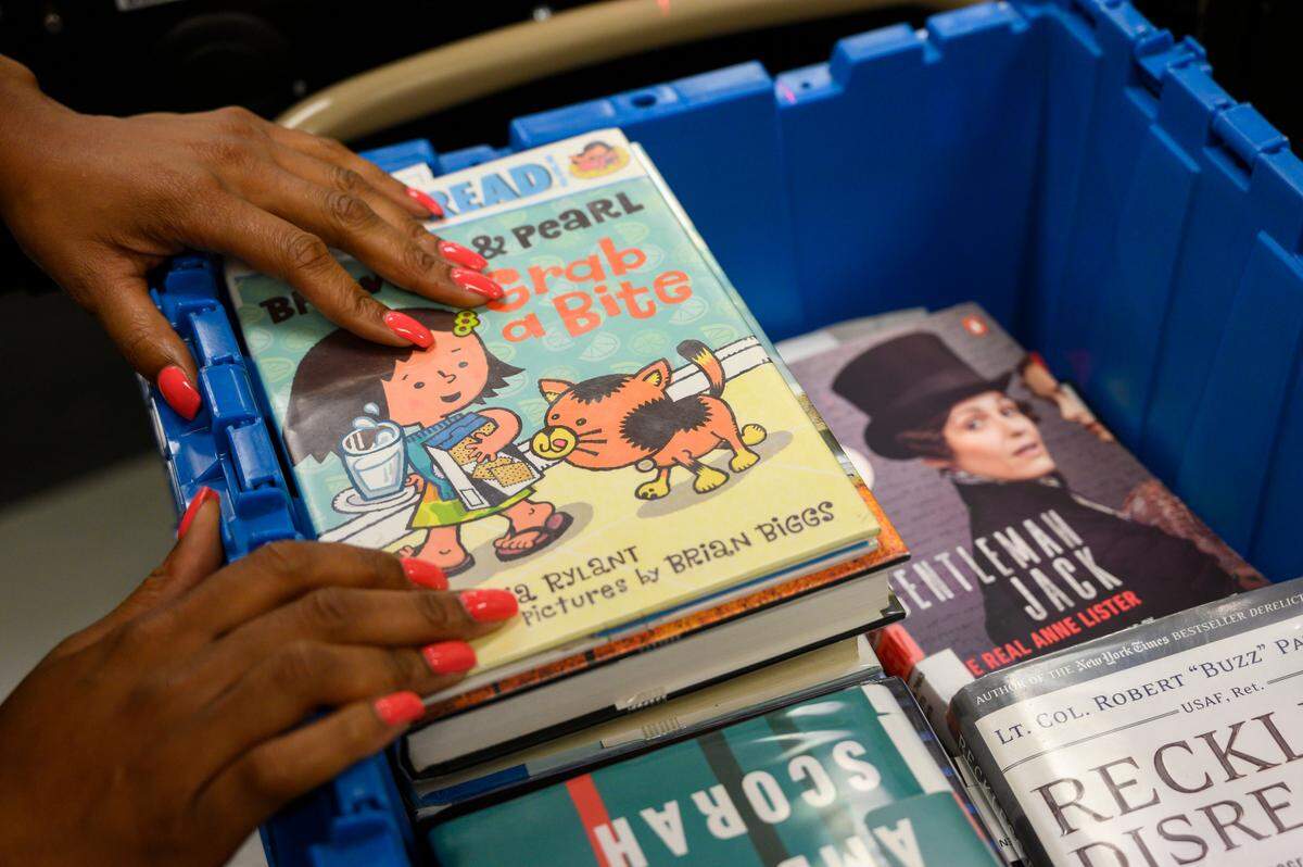 Tasia Graves prepares to send library books down a conveyor belt that sorts them by branch, Thursday, Aug. 22, 2019, at the Sacramento Public Library main downtown branch.