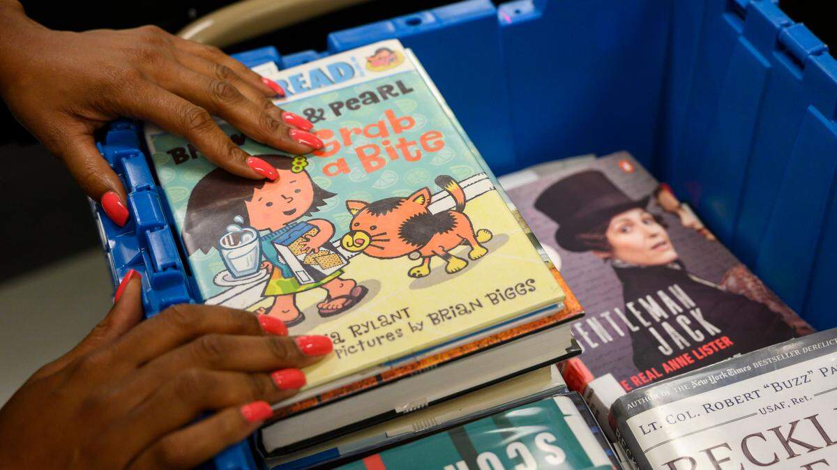 Tasia Graves prepares to send library books down a conveyor belt that sorts them by branch, Thursday, Aug. 22, 2019, at the Sacramento Public Library main downtown branch.