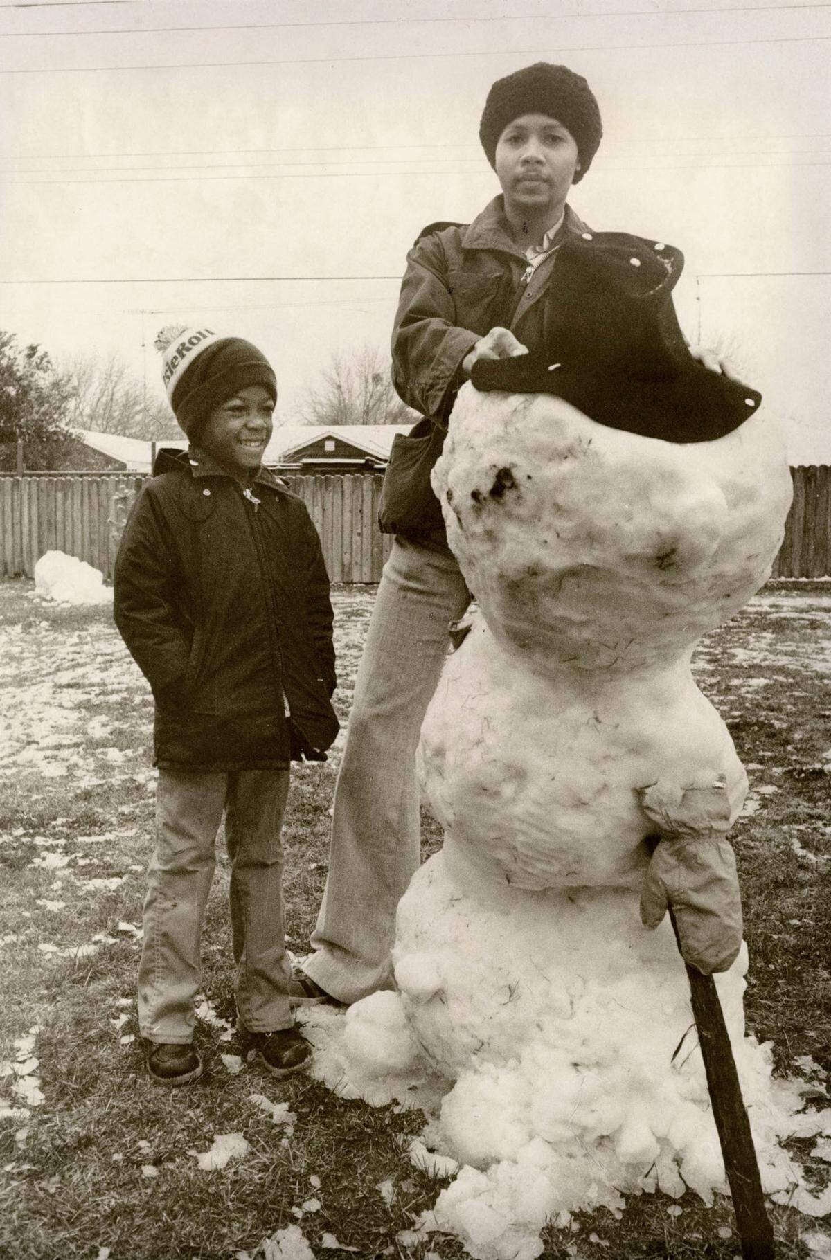 Stan Livermon and Charles Brown put the finishing touches on their snowman, February 5, 1976