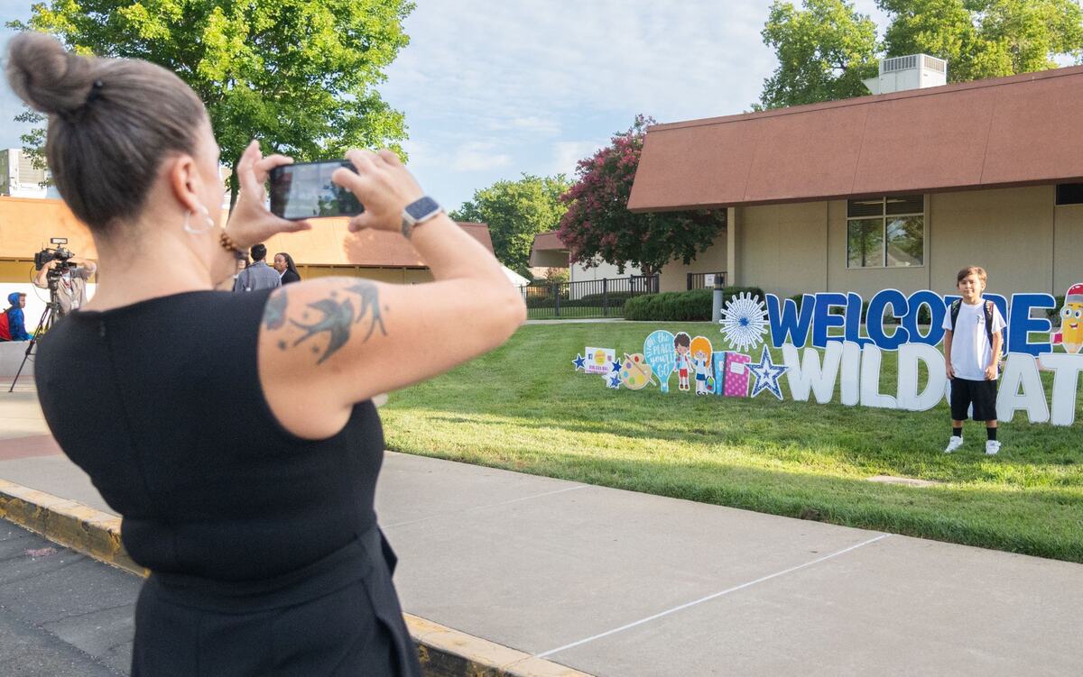 Julie Hernandez, left, takes a picture of her son Jackson Stacey on the first day of classes at Williamson Elementary School in Rancho Cordova on Thursday. Hernandez said Stacey, who is entering third grade, was pacing around the house before they left because he was excited to get to school.