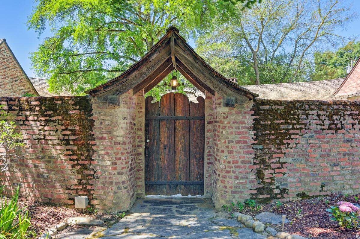 The wood-and-iron gate opens into the courtyard.