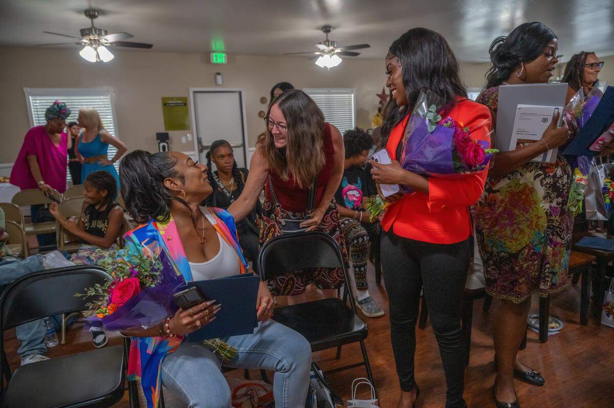 Shakela Wade, left, is congratulated after getting her certificate from the RENEW training program that could put her on the path to a career in property management earlier this month. Ward was previously homeless and is a graduate of the Women’s Empowerment program. Ward said the homeless population keeps growing and growing and she wants to be part of the solution for the unhoused.
