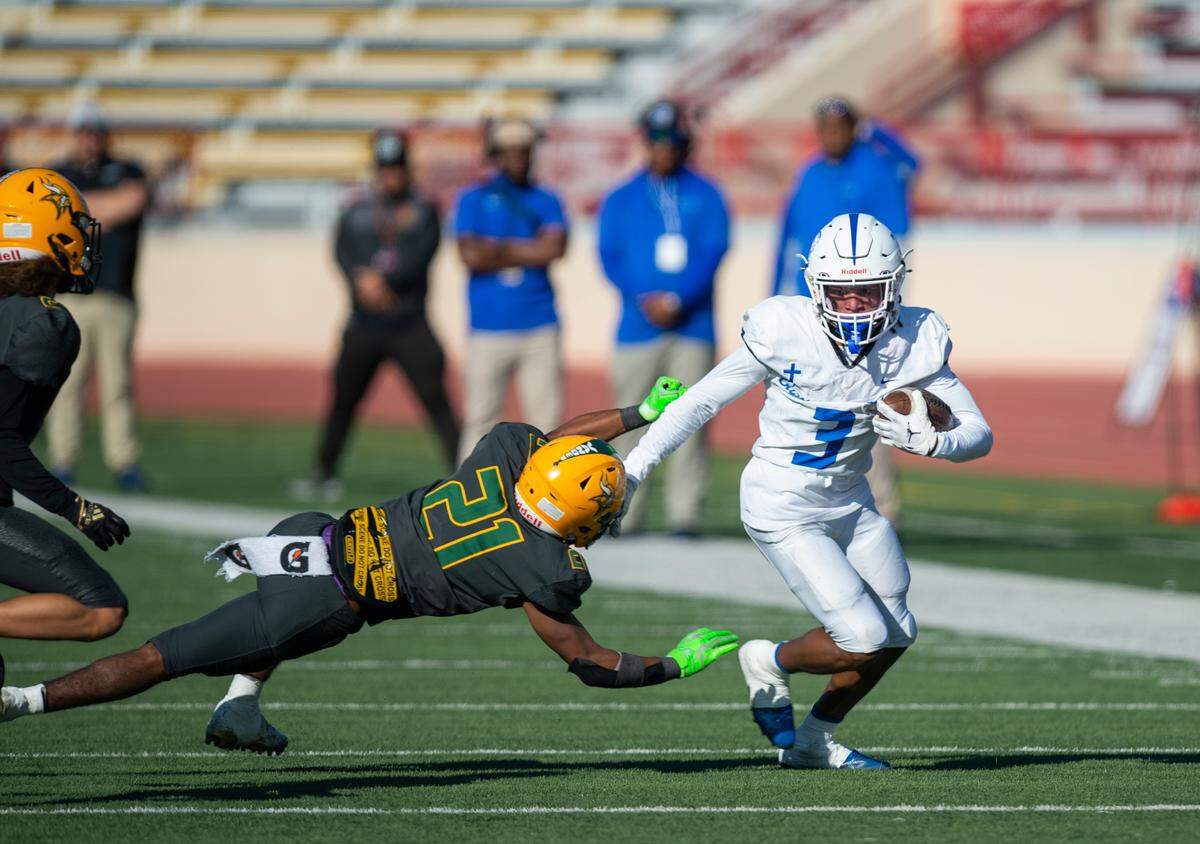 Capital Christian receiver Kanye Clark (3) evades Vanden’s Marcellus Chandler (21) in the first half of the CIF Sac-Joaquin Section Division IV championship football game at Hughes Stadium in Sacramento on Saturday.