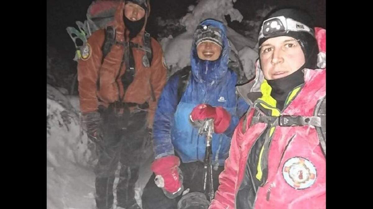 New Hampshire Department of Fish and Game workers found lost hiker Robert Cummings, 25, center, after he managed to post a plea for help to Facebook when he couldn’t reach 911.