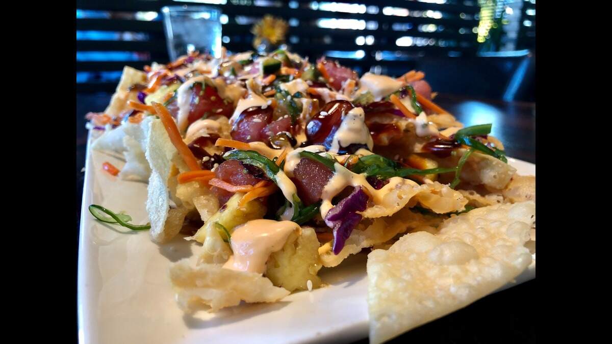 Goose Port’s spicy poke nacho platter includes tuna sashimi, pineapple and serrano chilis over a bed of wonton chips.