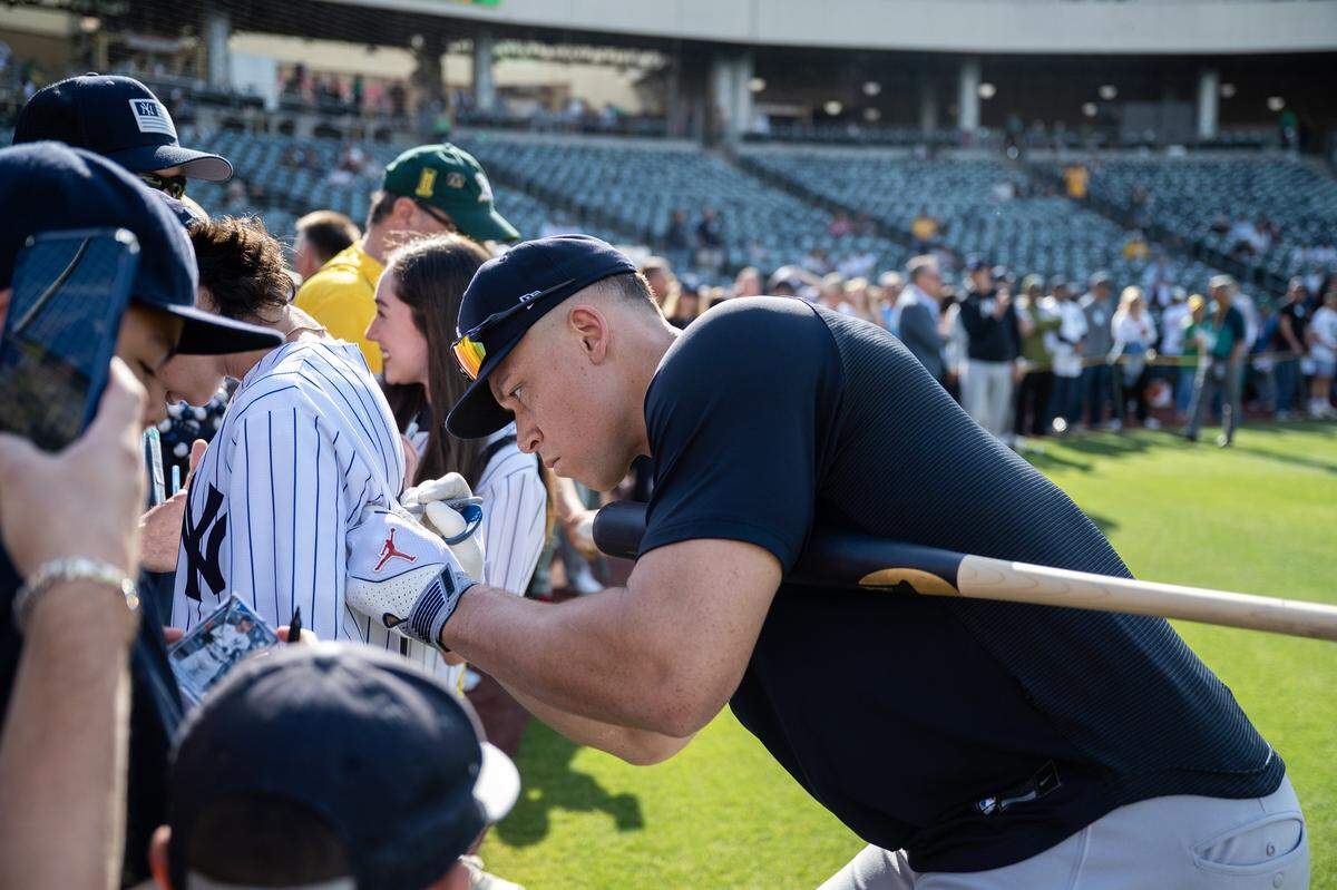 New York Yankees right fielder Aaron Judge signs autographs before the Yankees face the Athletics on Friday at Sutter Health Park in West Sacramento.