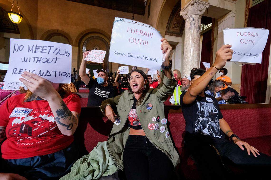 People hold signs and shout slogans as they protest before the cancellation of the Los Angeles City Council meeting Wednesday.