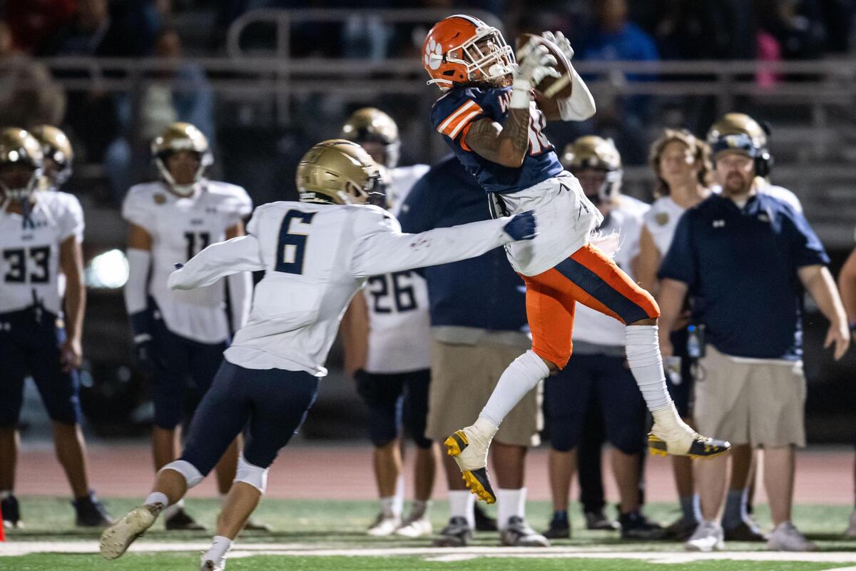 The Cosumnes Oaks Wolfpack’s Jared Quenga (10) pulls in a reception for a first down as Elk Grove Thundering Herd’s Hayden Gray (6) covers during the second quarter of the high school football game Friday at Cosumnes Oaks High School in Elk Grove.