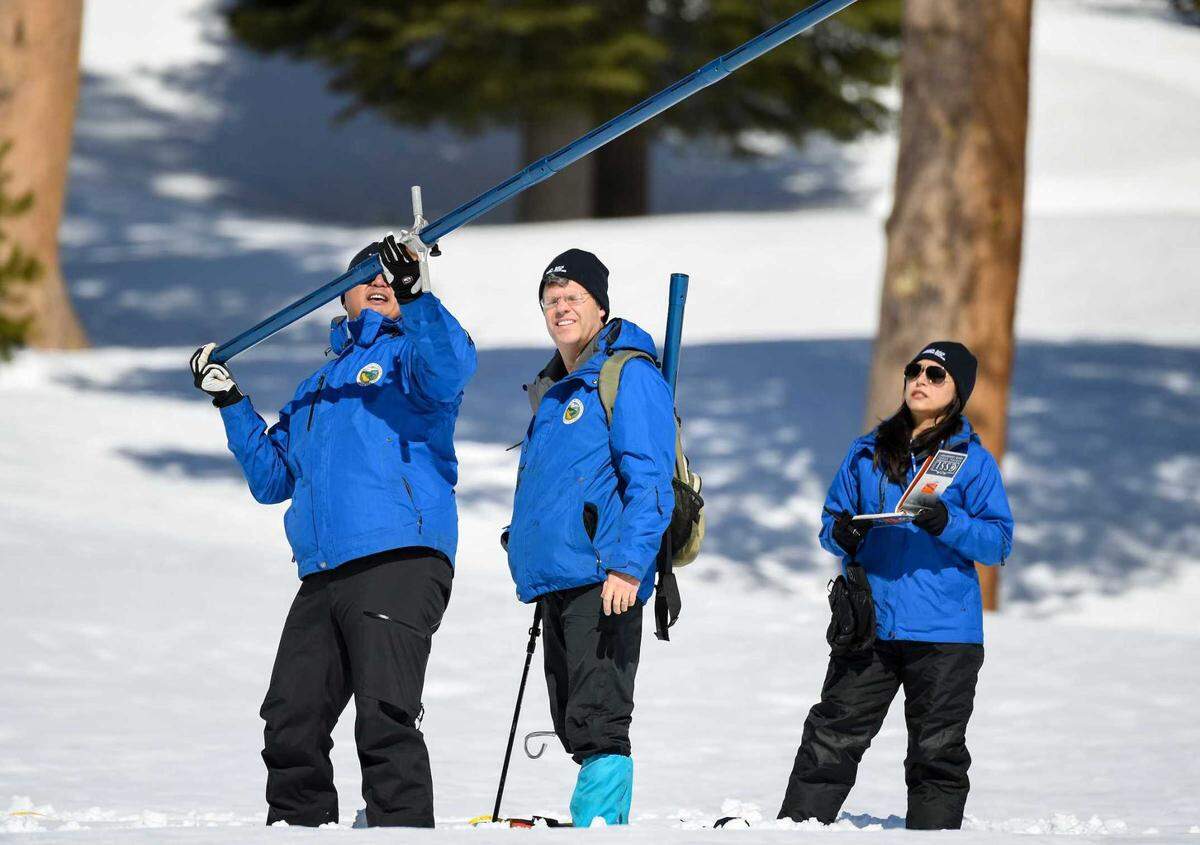 Sean de Guzman, left, and other officials from the California Department of Water Resources begin the measurement phase of the third media snow survey of the 2023 season at Phillips Station on Friday. The statewide average for snowpack across California’s mountains stood at 45 inches as of Friday, which is 190% of normal for the date and 171% of the April 1 average.