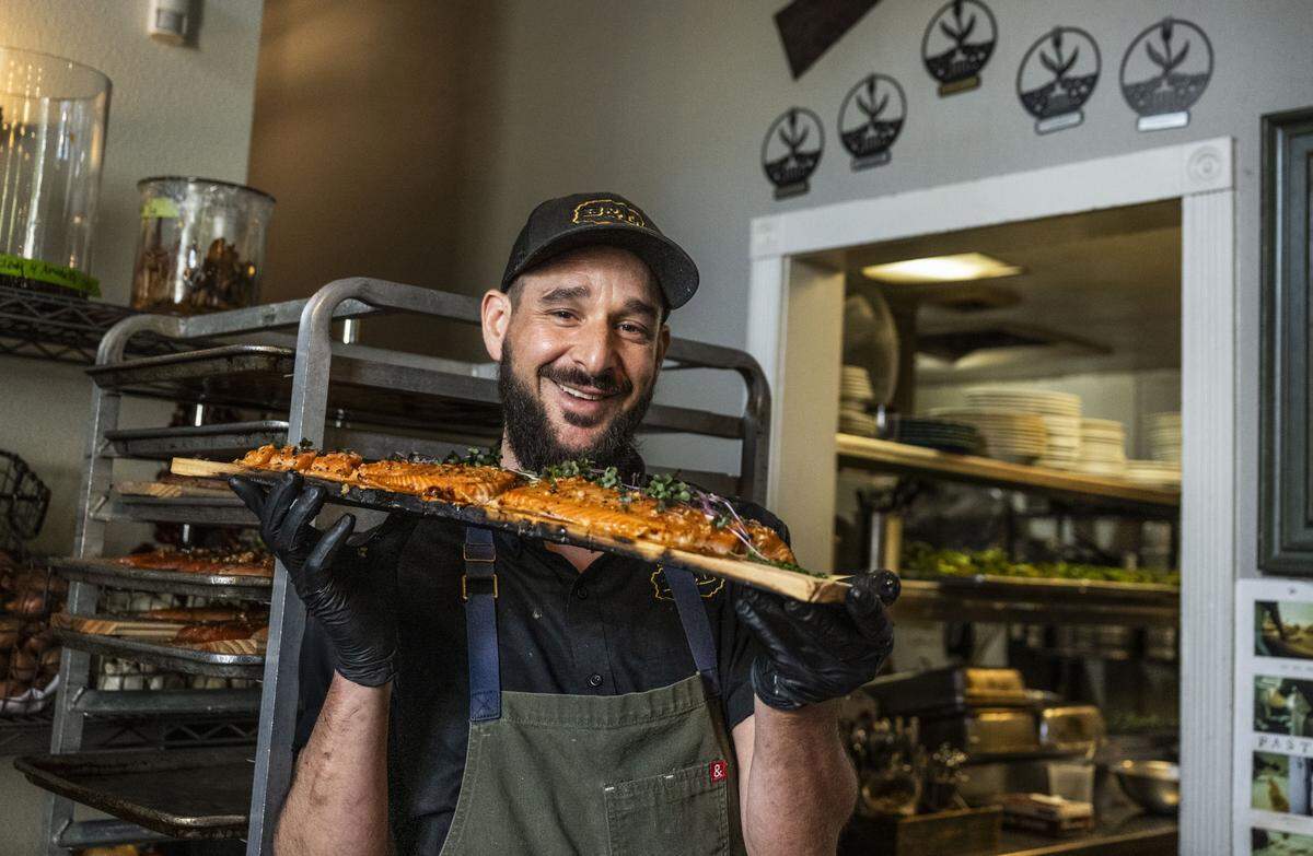Mulvaney’s B&L executive chef John Trujillo holds a cedar plank that was used to cook king salmon on Monday as the midtown Sacramento restaurant was serving the wild-caught fish from the California coast for the first time in three years.