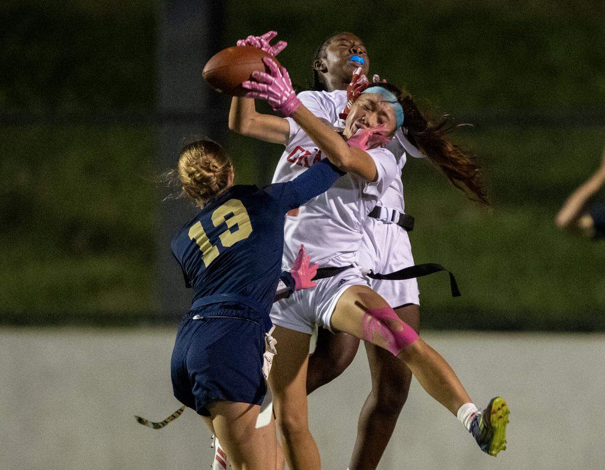 The McClatchy Lions’ Savanna Hill (1) catches a touchdown pass in front of teammate London Lee (11) and West Park’s Kelly Lane in the second half of the CIF Sac-Joaquin Section Division I flag football championship game Saturday at Cosumnes River College in Sacramento.