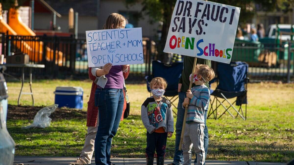 Rachel Klein of Davis holds a sign supporting reopening Davis schools for classroom instruction as a group called the DJUSD Parent Coalition held a rally at Central Park in Davis on Saturday, Feb. 6, 2021.