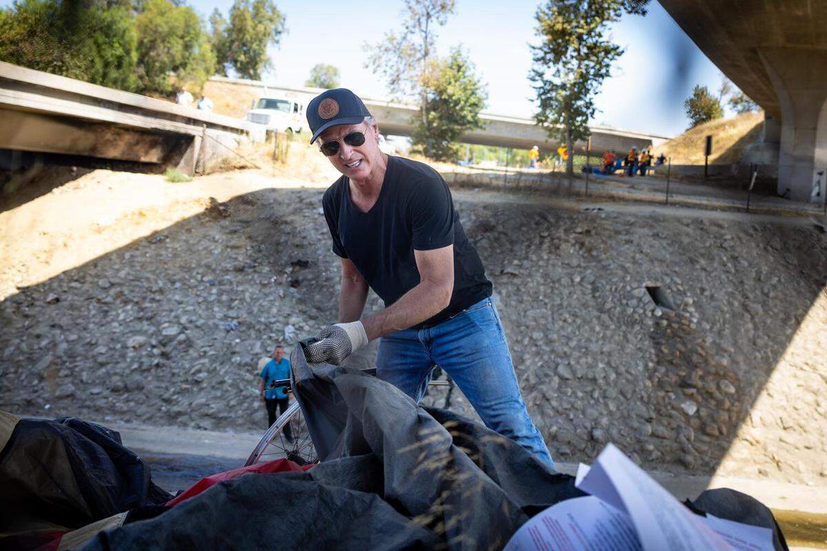 Gov. Gavin Newsom joins Caltrans workers to clean up an encampment site near Paxton Street and Remick Avenue in Los Angeles on Thursday, Aug. 8, 2024.